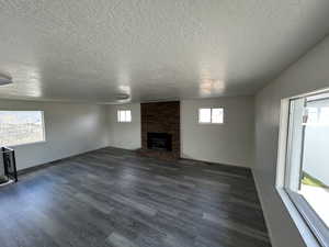 Huge Family Room w/ LVP flooring, a textured ceiling, and a brick fireplace