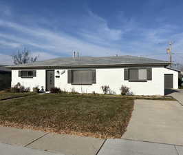 Ranch-style house with an outbuilding, a front yard, and a garage