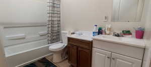 Full bathroom with tile patterned flooring, vanity, toilet, and shower / bathtub combination with curtain