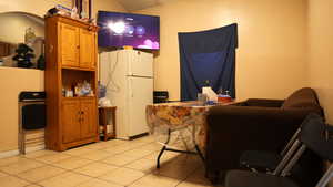 Interior space featuring light tile patterned floors and white refrigerator