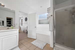 Bathroom featuring tile patterned flooring, vanity, and plus walk in shower