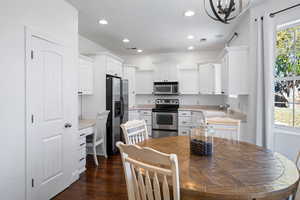 Kitchen featuring plenty of natural light, white cabinets, stainless steel appliances, and dark hardwood / wood-style floors