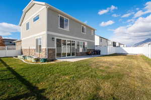 Rear view of property featuring a yard and a patio