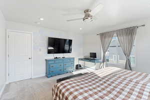 Carpeted bedroom featuring ceiling fan