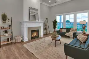 Living room featuring a fireplace, a towering ceiling, and light wood-type flooring