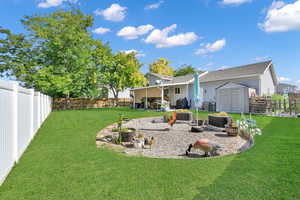 Rear view of house featuring a lawn, an outdoor living space, a patio area, and a shed