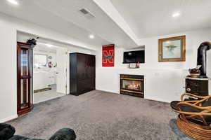 Living area with a fireplace and carpet floors