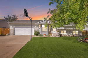 View of front of house featuring a lawn and a garage