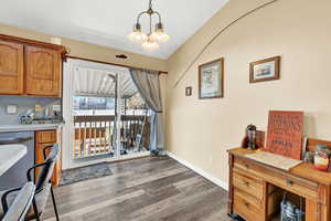 Dining space with dark hardwood / wood-style flooring and an inviting chandelier