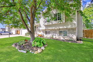 Tri level home featuring a garage and a front lawn