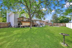 View of yard with central AC unit and a wooden deck