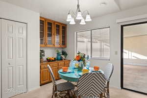 Carpeted dining room featuring a notable chandelier