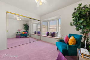 Living area with ceiling fan and carpet