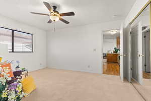 Bedroom with ceiling fan, a closet, a textured ceiling, and light wood-type flooring