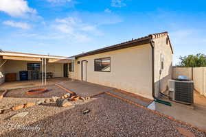 Back of property with a patio and central AC