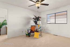 Sitting room with light carpet and ceiling fan