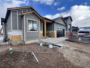 View of front of house featuring a garage and a sunroom