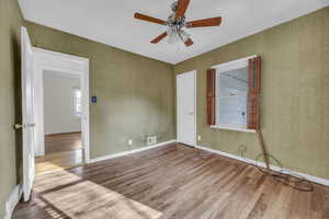 Unfurnished room featuring ceiling fan and hardwood flooring