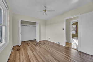 Unfurnished bedroom with hardwood flooring, a closet, and ceiling fan