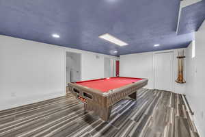 Game room with  dark hardwood / wood-style tile floors, and pool table