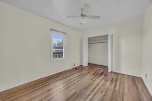 Unfurnished bedroom featuring hardwood flooring, a closet, and ceiling fan