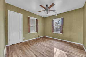 Spare room featuring ceiling fan and hardwood flooring