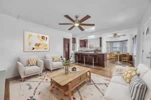 Living room featuring ceiling fan and light hardwood flooring