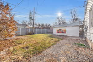 View of backyard featuring garage and storage shed