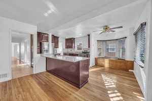 Kitchen featuring backsplash, sink, light hardwood / wood-style flooring, appliances with stainless steel finishes, and kitchen peninsula