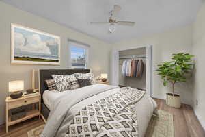 Bedroom with ceiling fan, a closet, and hardwood flooring- digitally staged