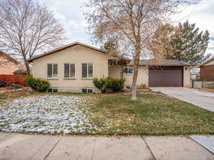 View of front of property featuring a 2 car- garage and a front lawn