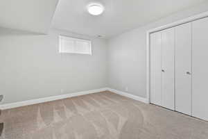 Unfurnished bedroom featuring light colored carpet, a textured ceiling, and a closet