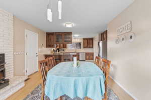 Dining room with a fireplace and light hardwood / wood-style flooring