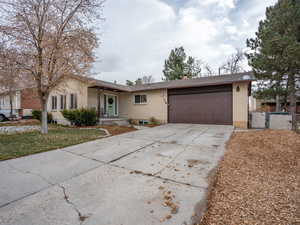 Ranch-style house with a garage and a front lawn