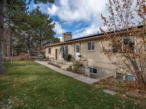 Rear view of house featuring a lawn