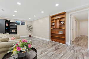 Living room featuring light wood-type flooring and ornamental molding