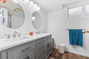 Bathroom with hardwood / wood-style floors, vanity, and a textured ceiling