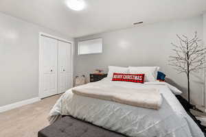 Bedroom featuring a textured ceiling, carpet floors, and a closet