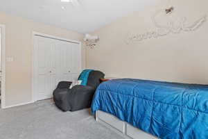 Bedroom featuring carpet, ceiling fan, and a closet