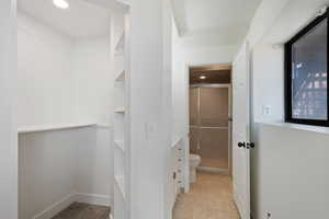 Bathroom featuring toilet and a shower with shower door