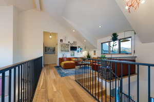 Hall featuring a chandelier, hardwood / wood-style floors, and lofted ceiling with beams