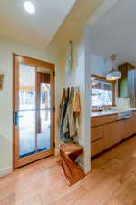 Doorway featuring sink, a healthy amount of sunlight, and light hardwood / wood-style floors