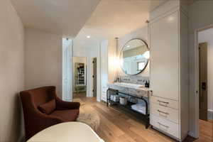 Bathroom with vanity, hardwood / wood-style flooring, and backsplash