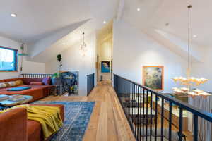 Living room with beam ceiling, light wood-type flooring, high vaulted ceiling, and a notable chandelier