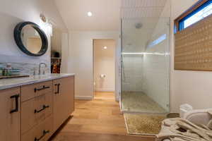 Bathroom with lofted ceiling, toilet, a shower with door, vanity, and hardwood / wood-style flooring