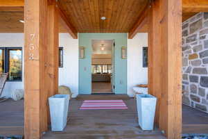 Doorway to property featuring covered porch