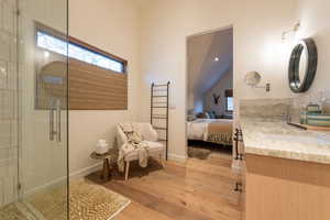 Bathroom with hardwood / wood-style floors, vanity, and a shower with shower door