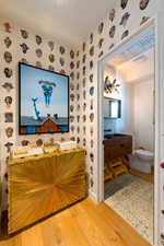 Bathroom with hardwood / wood-style flooring, vanity, and toilet