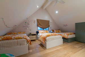 Bedroom featuring vaulted ceiling with beams, ceiling fan, and light hardwood / wood-style floors