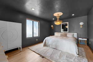 Bedroom featuring a chandelier and light wood-type flooring